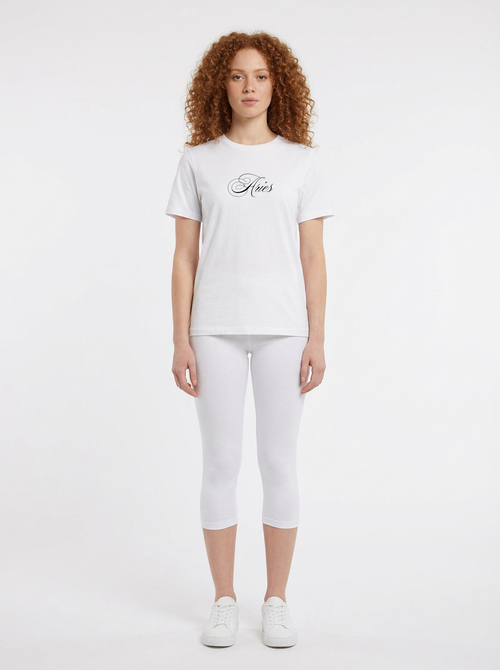 Model in the Aries White Top with white capris